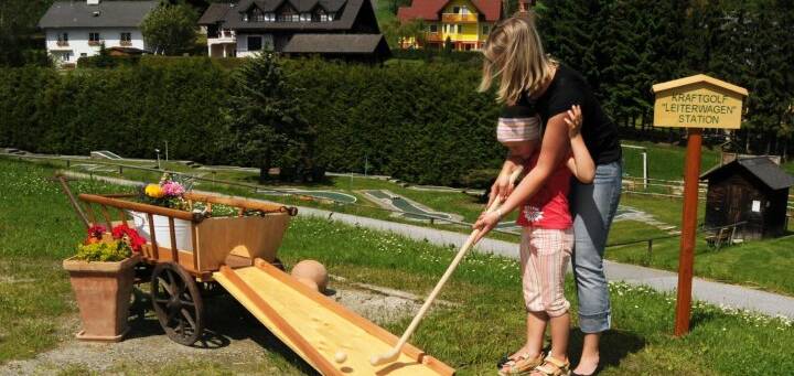 Miutter und Kind spielen Kraft-Golf in St. Jakob im Walde