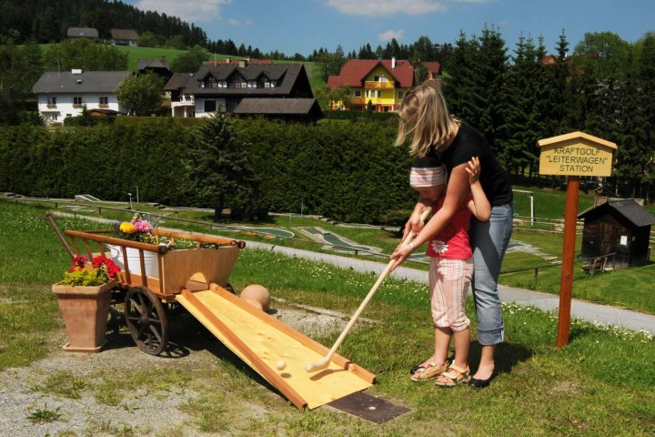 Miutter und Kind spielen Kraft-Golf in St. Jakob im Walde
